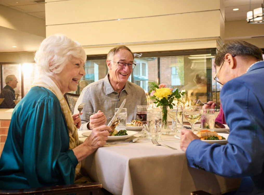 group of well-dressed senior friends enjoying a meal together in an elegant setting