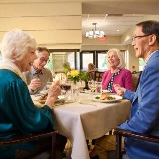 group of well-dressed senior friends enjoying a meal together in an elegant setting